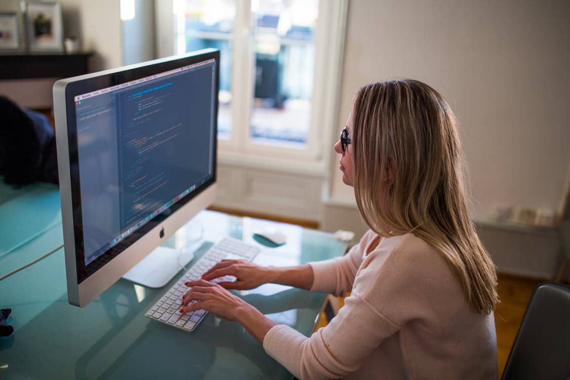 girl doing programming on a Mac PC